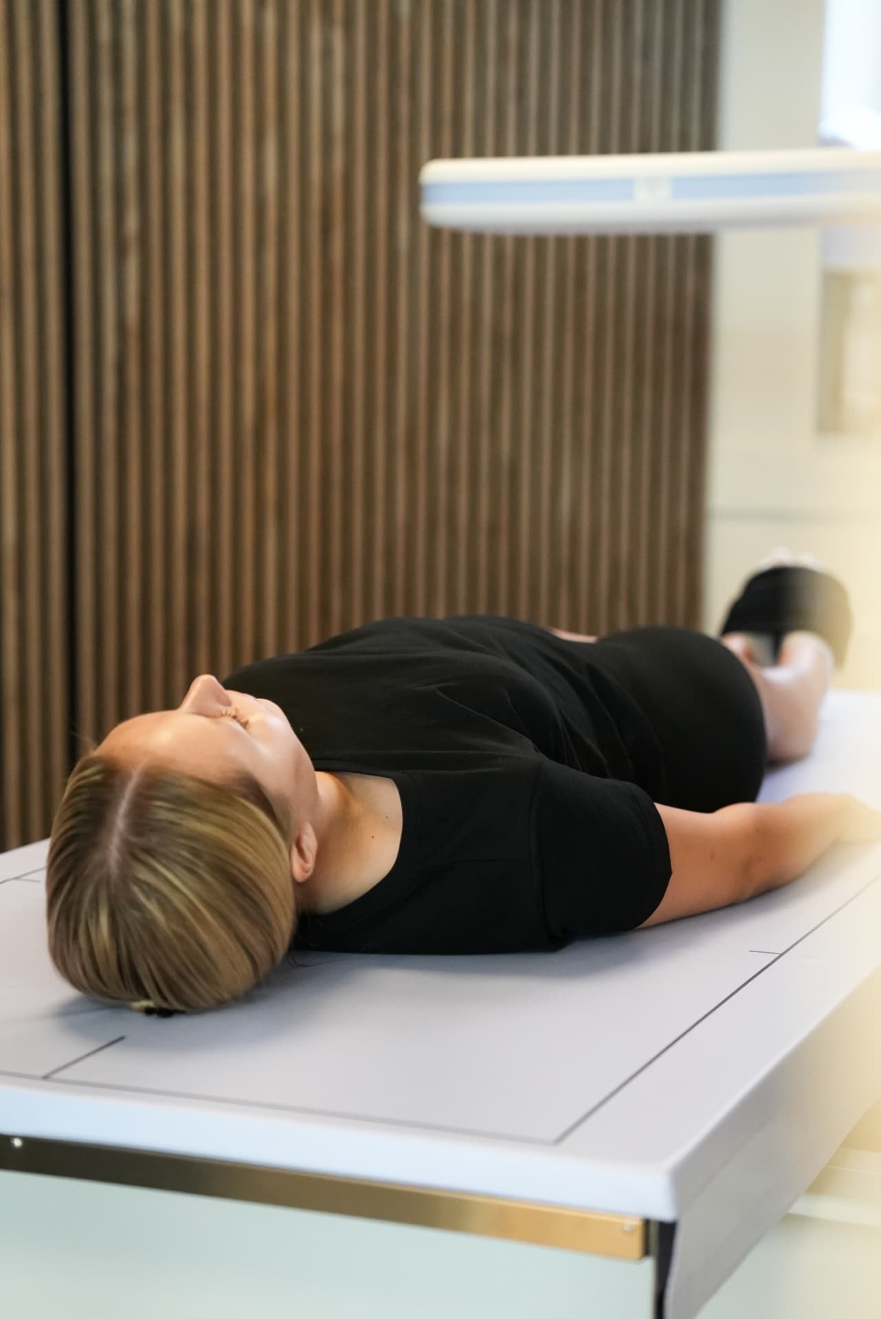 Patient som ligger på DEXA-britsen hos Revi Health Stockholm City